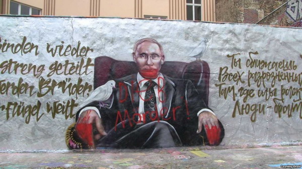 На «поздравительном» портрете Путина в центре Берлина написали «Убийца и вор»: фото
