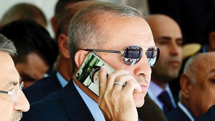 Эрдоган говорит по телефону, на котором его собственный портрет